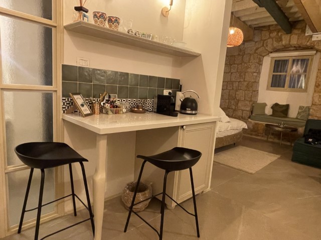 דלפק ישיבה עם כסאות בר, מכונת אספרסו ומיני בר בסוויטת אמרלד