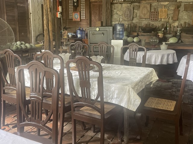 חדר אוכל בסגנון כפרי-פיליפיני עם שולחן ארוך מוכן לארוחת צהריים