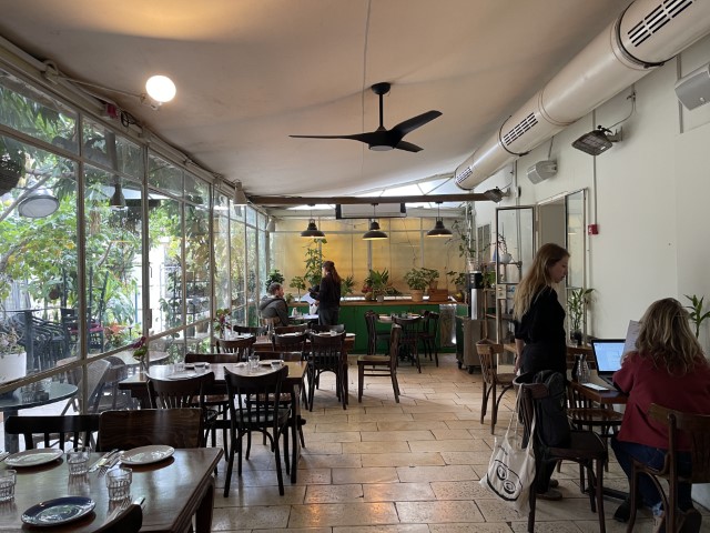 חלל פנימי מעוצב בריהוט שנות ה-50 עם חלונות גדולים המשקיפים לגינה