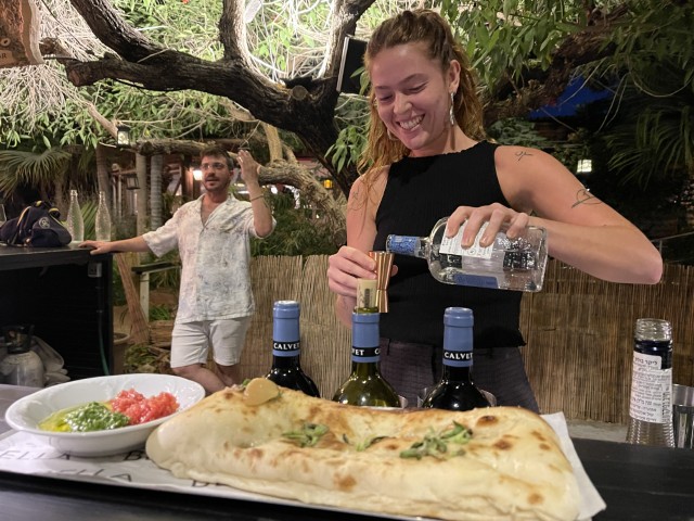 ערבה משקשקת קוקטיילים על הבר בחצר של מסעדת בלה