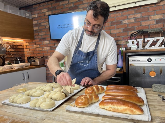 אסף מדגים הכנת לחמניות קלועות בסדנת אפייה
