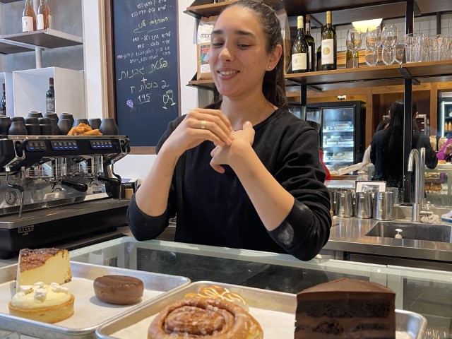 פנינה ריבק מסבירה על העוגות בקונדיטוריית פרלין