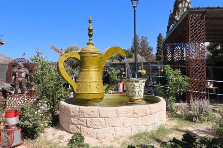 קנקן קפה וספל ענקי בתוך באר מים, יצירת פסולת ממוחזרת מוזיאון שעב