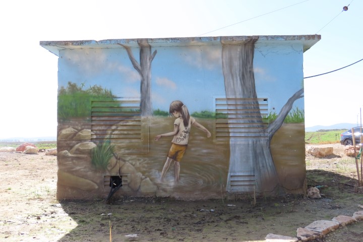 גרפיטי של ילדה משחקת במים במעיין עדעד